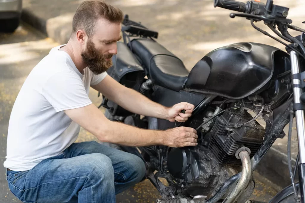 focused rider trying reanimate broken motorbike 1262 17366 focused rider trying reanimate broken motorbike 1262 17366